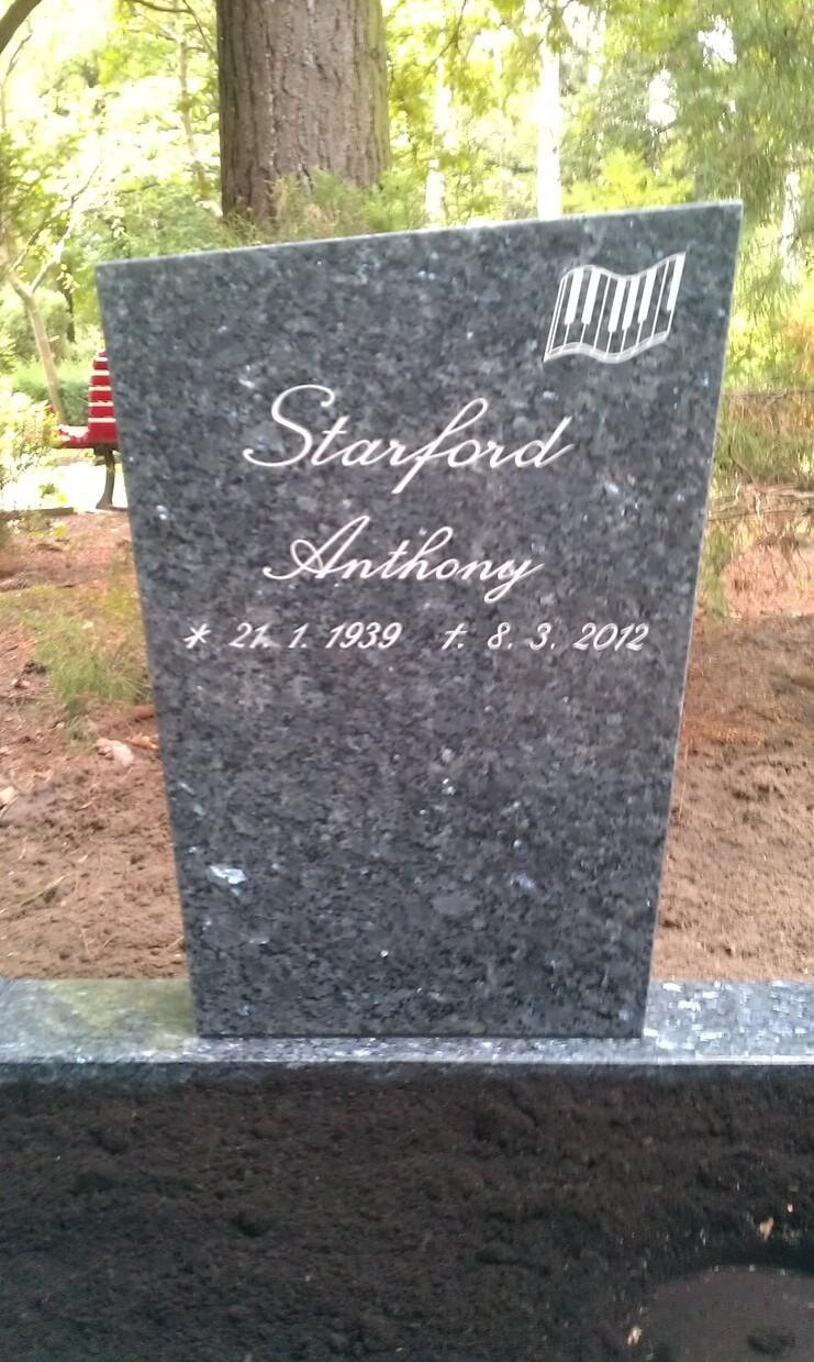 Schwarzer Grabstein mit der Inschrift &bdquo;Starford Anthony&ldquo; und den Geburts- und Sterbedaten, umgeben von Natur.